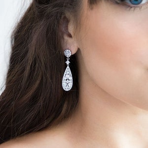 May include: Silver teardrop earrings with a cluster of clear cubic zirconia stones.