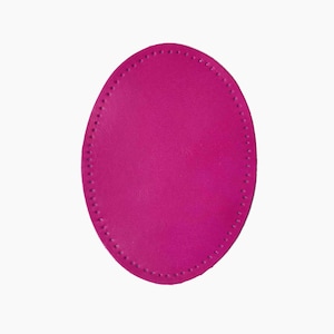 Op de afbeelding: Een helder magenta, ovaalvormig leren stuk met een gestikte rand. Het leer heeft een gladde textuur en een consistente kleur. De stiksels zijn gelijkmatig verdeeld rond de rand, waardoor een duidelijke omtrek ontstaat.