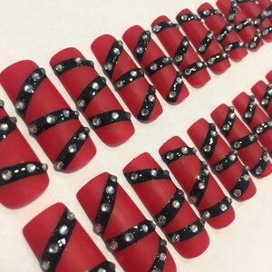 赤と黒のつけ爪。長めのスクエアプレスネイル
