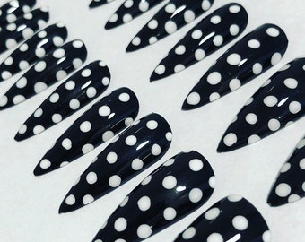 May include: Set of black stiletto false nails with white polka dots.