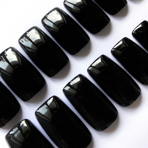 May include: A set of ten black square-shaped false nails.