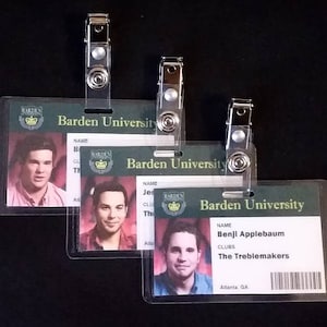 May include: Three clear plastic ID cards with a green and gold Barden University logo. The cards have a photo, name, and clubs listed. The text on the bottom card reads "Benji Applebaum, The Treblemakers, Atlanta GA".