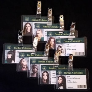 May include: Nine plastic ID cards with a green background and gold accents. Each card has a photo of a different person and the text "Barden University" at the top. The cards also include the names "Aubrey Posen", "Emily", and "Florencia Fuentes".