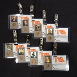 May include: A collection of eight rectangular plastic ID badges featuring the Time Variance Authority logo in orange. Each badge includes a character portrait, a gold circular seal, and a white label with the name and rank of the variant.