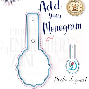 May include: An embroidery design file featuring a scalloped-edge tag shape with a vertical tab containing two circular holes. The design includes blue and pink stitching outlines. Text reads Add your Monogram and Make it yours.