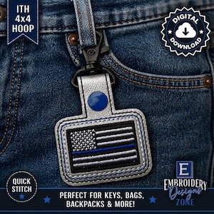 May include: A silver keychain featuring a black and white American flag with a blue stripe. The keychain has a blue button and a black clasp. The image includes the text "DIGITAL DOWNLOAD" and "QUICK STITCH".