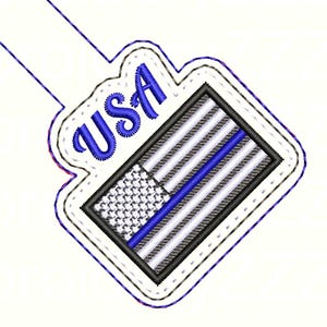 Puede incluir: Parche bordado con la bandera estadounidense con una franja azul y la palabra "USA" en escritura azul. El dise&ntilde;o de la bandera incluye rayas negras, blancas y grises, con una l&iacute;nea azul. El parche tiene un borde blanco.