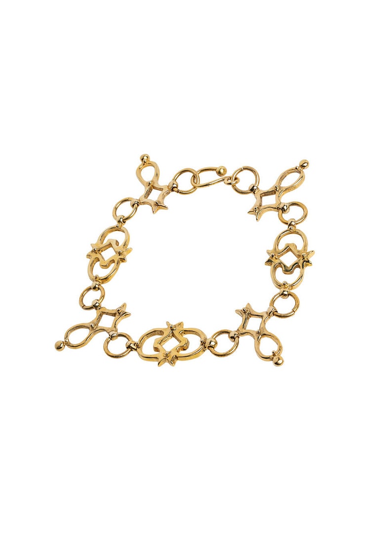 Puede incluir: Un brazalete de cadena de oro con un dise&ntilde;o &uacute;nico e intrincado que presenta c&iacute;rculos entrelazados y acentos en forma de estrella.