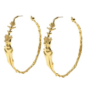May include: A pair of gold hoop earrings with a textured finish. Each earring features a sculpted female figure with a floral design at the top.