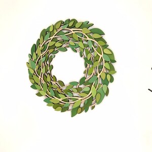May include: A green paper wreath with leaves and branches, perfect for a spring or summer decor.