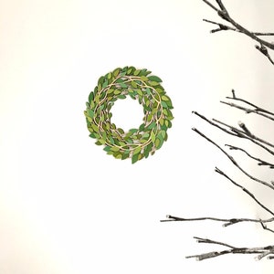 May include: A green leaf wreath with a natural twig base, hanging on a white wall. The wreath is made of individual green leaves and twigs, creating a natural and rustic look.