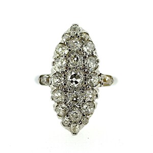May include: A silver ring with a marquise-shaped setting featuring a cluster of small, round diamonds.