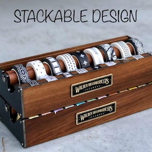 May include: A wooden organizer for storing washi tape. The organizer is made of dark wood and has a black metal frame. It is labeled "Walden Woodworkers" and features a stackable design.