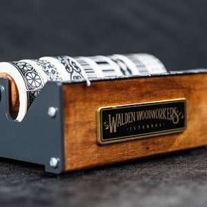 May include: A wooden and metal tape dispenser with four rolls of patterned washi tape. The dispenser has a label that reads "Walden Woodworkers - Istanbul."