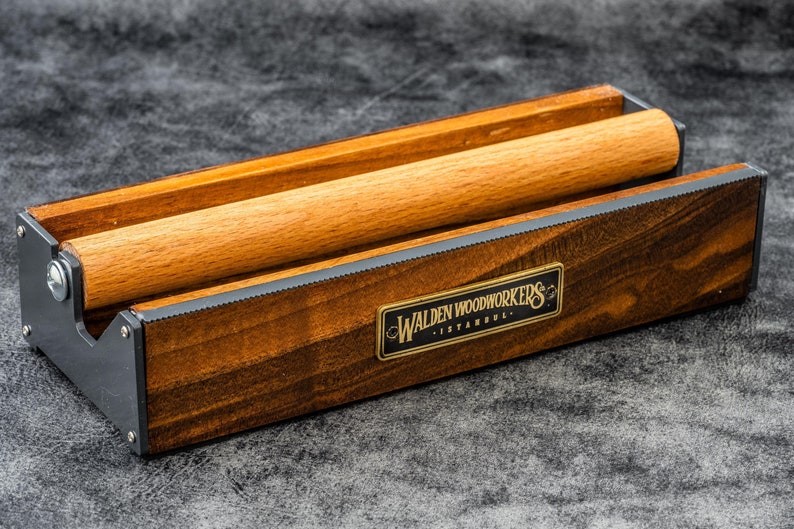 May include: A wooden rolling pin holder with a metal frame and a brass plaque that reads "Walden Woodworkers - Istanbul".