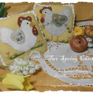 May include: Two felt applique pillow patterns featuring a pair of chicks with yellow and brown accents. The pattern is titled "Two Spring Chicks" and is by Diane Knett LLC.