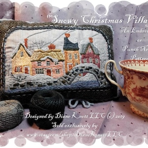 Pode incluir: Um padrão de bordado com agulha de punção para uma cena de vila natalina com neve. O padrão apresenta uma ponte, casas e árvores. O padrão foi projetado por Diane Knett LLT e é vendido exclusivamente no Etsy.