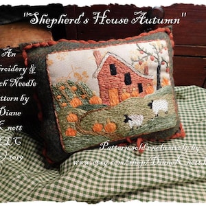 Könnte beinhalten: Ein grünes und braunes Filzkissen mit einem gestickten Bild eines roten Bauernhauses, einem Kürbisfeld und zwei Schafen. Der Text "Shepherd's House Autumn" ist über dem Bild geschrieben. Der Text "An Embroidery & Punch Needle Pattern by Diane Knott LLG (c)2019" ist unter dem Bild geschrieben. Der Text "Pattern sold exclusively by www.etsy.com/shop/Diane Knott LLC" ist unter dem Kissen geschrieben.