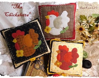 May include: Three handmade felt pillows featuring a chicken design. The pillows are brown, white, and red with yellow flowers and green leaves. The pillows are titled "Ms. Chickaletta" and are for sale on Etsy.