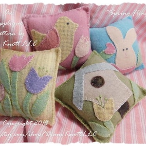 May include: Four felt pillow patterns for spring, featuring a bird, a bunny, a birdhouse, and flowers. The patterns are titled "Spring Fling" and are by Diane Knott LLC.