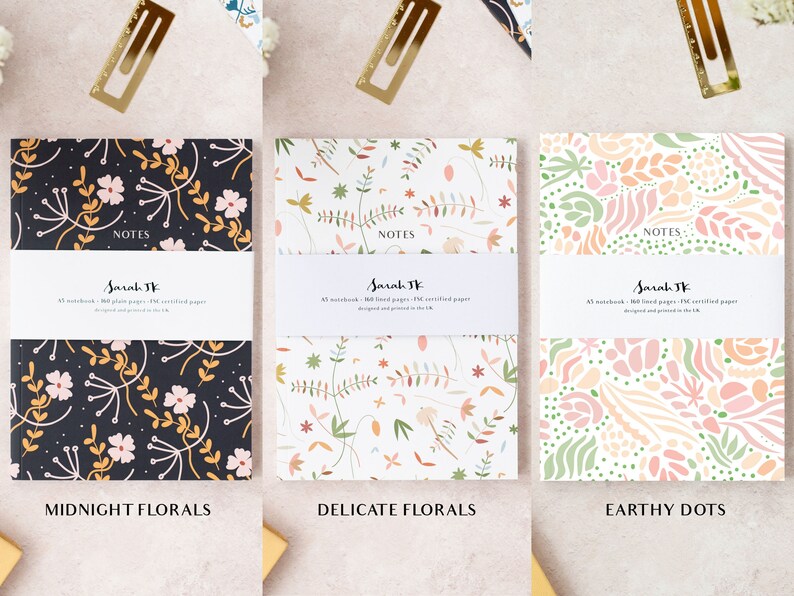 May include: Three notebooks with different floral designs. The notebooks are titled "Midnight Florals", "Delicate Florals", and "Earthy Dots". Each notebook has the text "NOTES" and "Sarah JK" printed on the front.