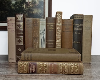 May include: A collection of vintage hardcover books in shades of brown, tan, and beige. The stack includes titles such as Raiders of Spanish Peaks, The House of the Seven Gables, The Desert of Wheat, Essays and Poems, and Conquest of Mexico.