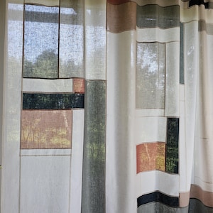 May include: Curtains with a geometric pattern in white, beige, brown, black, and green. The design features rectangular and square shapes, creating a modern and artistic look. The curtains are hanging from a rod and appear to be made of a light, airy fabric.