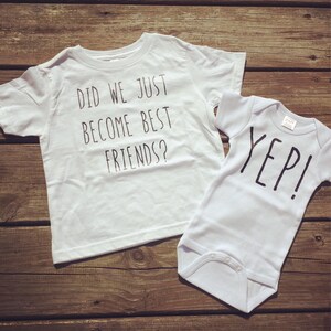 May include: Two white shirts with black text. The larger shirt says "Did we just become best friends?" and the smaller shirt says "Yep!"