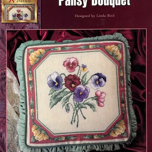 May include: A cross-stitch pattern for a pillow featuring a pansy bouquet. The design size is 13.5 x 13.5 inches, and the finished pillow size is 16 x 16 inches. The design includes red, purple, and yellow pansies.