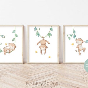 May include: Three framed prints featuring watercolor illustrations of monkeys swinging on vines. Each print has a different monkey pose and is set against a white background with green vines.
