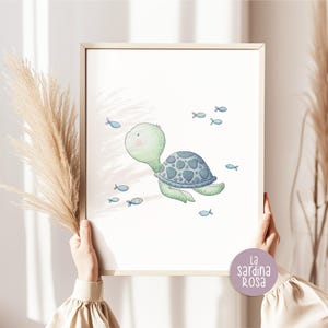 May include: A watercolor illustration of a green sea turtle swimming with blue fish. The turtle has a blue and gray shell and is swimming in a light blue ocean. The illustration is surrounded by a white border.