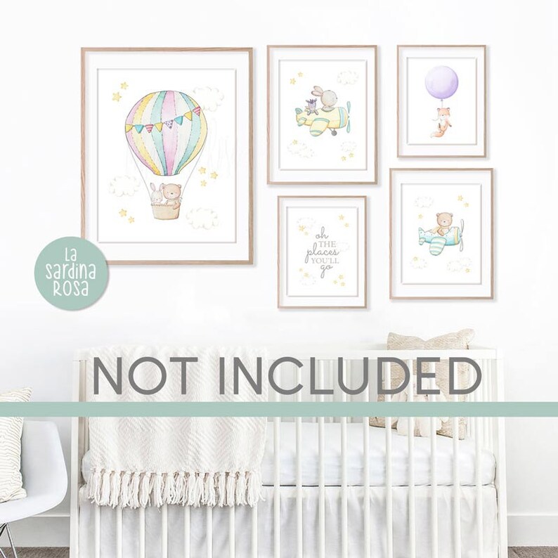 May include: A set of five watercolor prints featuring a hot air balloon, a plane, a fox with a balloon, a quote about places you'll go, and a bear in a plane. The prints are framed in light wood and are displayed on a white wall above a white crib.