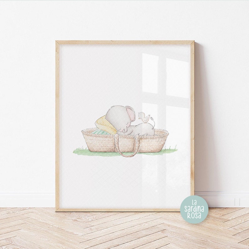 Pode incluir: Uma ilustra&ccedil;&atilde;o em aquarela de um elefante cinza dormindo em uma cesta de vime marrom com um travesseiro amarelo. Um pequeno p&aacute;ssaro est&aacute; empoleirado na borda da cesta.