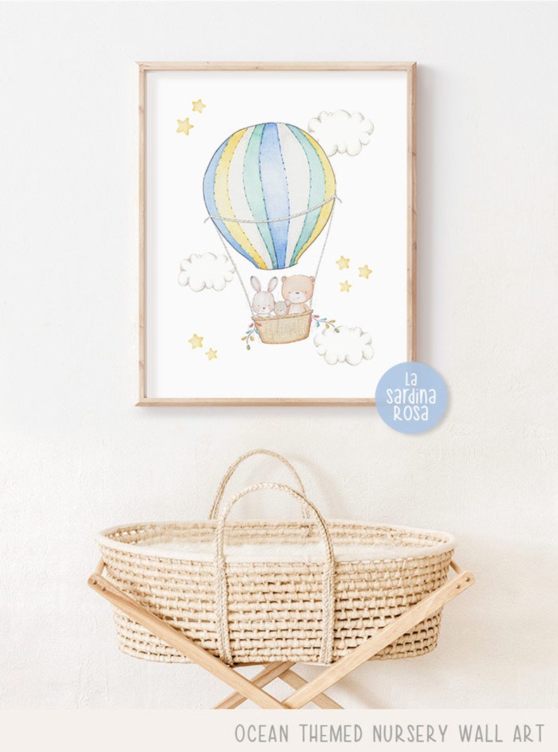 May include: A watercolor illustration of a hot air balloon with a bear and a bunny inside. The balloon is yellow, blue, and green with white stripes. The balloon is surrounded by white clouds and yellow stars. The text "La Sardina Rosa" is in the bottom right corner of the image.