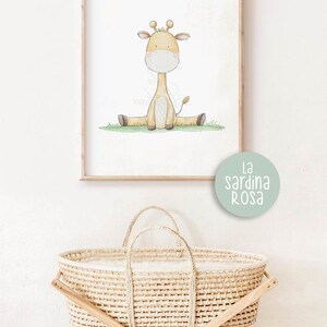 Puede incluir: Una ilustraci&oacute;n de acuarela de una linda jirafa sentada en un parche de hierba verde. La ilustraci&oacute;n est&aacute; enmarcada y colgada en una pared blanca. El texto "la sardina rosa" est&aacute; impreso en un c&iacute;rculo verde claro debajo del marco.