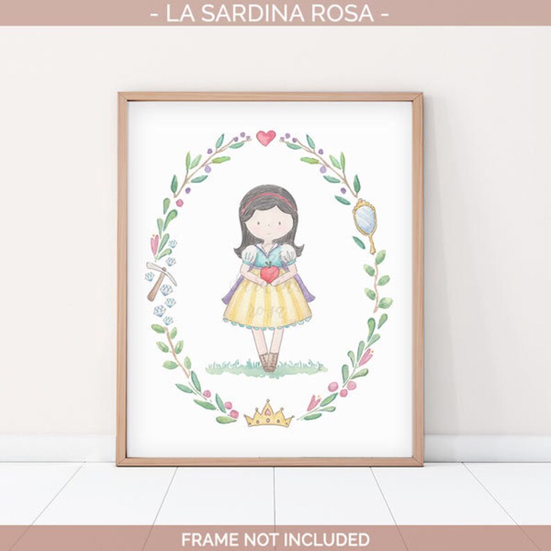 May include: A watercolor illustration of Snow White, a Disney princess, holding a red apple. She is surrounded by a wreath of green leaves and flowers. The illustration is framed in a light brown frame.