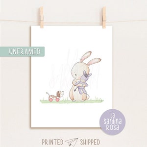 Puede incluir: Una ilustraci&oacute;n de acuarela de un conejo marr&oacute;n sosteniendo un animal de peluche morado. Un perro marr&oacute;n y blanco con ruedas rojas camina detr&aacute;s del conejo. La ilustraci&oacute;n est&aacute; sobre un fondo blanco con hierba verde.