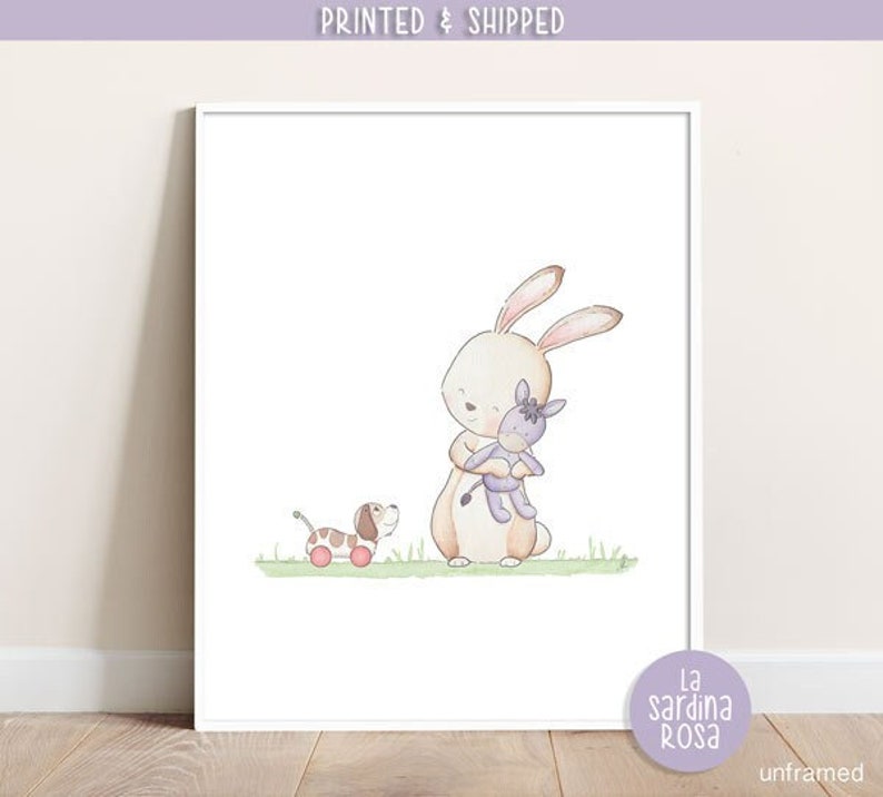 Puede incluir: Una ilustraci&oacute;n de acuarela de un conejo marr&oacute;n sosteniendo un burro de peluche morado. Un perro marr&oacute;n y blanco con ruedas rojas est&aacute; en el fondo. La ilustraci&oacute;n est&aacute; sobre un fondo blanco con hierba verde.