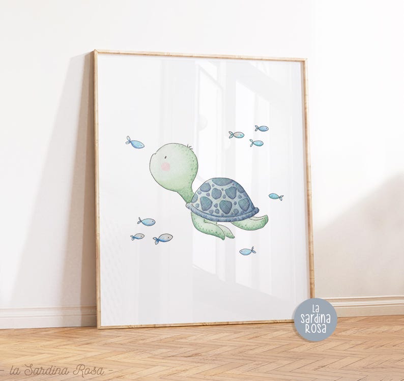May include: A watercolor illustration of a green sea turtle swimming with blue fish. The turtle has a blue and gray shell and is surrounded by small blue fish. The illustration is on a white background and is framed in a light wood frame.