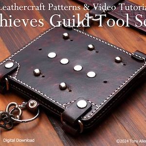 May include: A brown leather tool pouch with white stitching detail and silver rivets. The pouch has a metal loop and a key chain attached. The text "Thieves Guild Tool Set" is visible in the image.