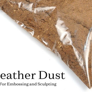 May include: A close-up of a plastic bag filled with brown leather dust. The bag is labeled "Leather Dust" and "For Embossing and Sculpting".