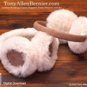 May include: A pair of white faux fur earmuffs with a brown leather headband. The earmuffs are lying on a wooden surface.  Digital Download. ©2024 Tony Allen Bernier