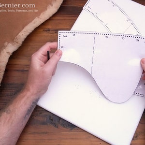 May include: A white paper pattern for a leather project with measurements marked in inches. The pattern is labeled "Back" and "Front".