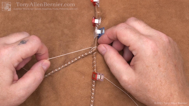 May include: Close-up of leatherworking with hands manipulating thread and leather. The image shows a detailed view of a sewing process, with the text "TonyAllenBernier.com" visible in the top left corner.