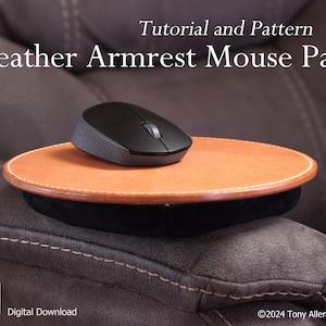 Puede incluir: Un reposabrazos de ratón de cuero marrón claro con un ratón inalámbrico negro. La almohadilla tiene un borde cosido blanco y una base acolchada negra. El texto de la imagen dice "Tutorial and Pattern" y "Leather Armrest Mouse Pad".