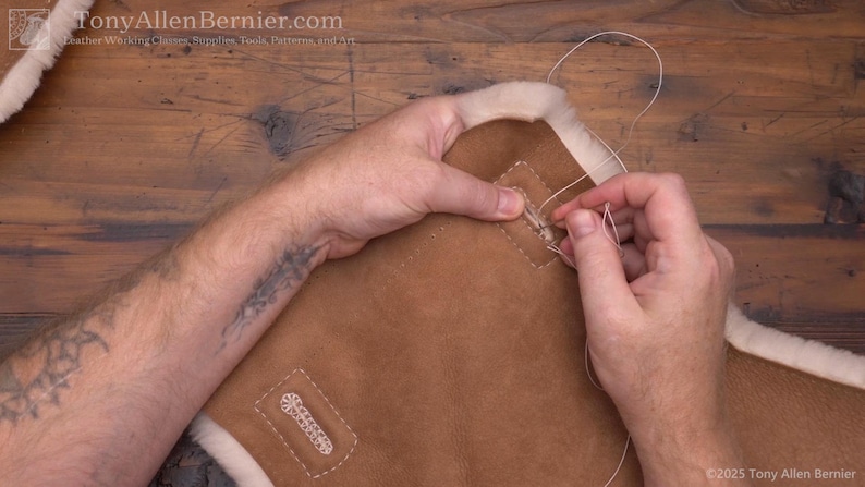 May include: Close-up of leatherworking. A person is hand-stitching a brown leather piece with white thread. The leather has a light-colored, fluffy trim. The image includes the website address TonyAllenBernier.com.