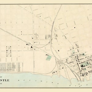 May include: A vintage map of New Castle, Delaware, showing the city's streets and buildings. The map is printed in black and white on a cream-colored background. The Delaware River is shown in blue.