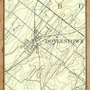 Puede incluir: Un mapa topográfico antiguo de Doylestown, Pensilvania, con curvas de nivel, carreteras y cursos de agua. El mapa, fechado en 1890, presenta el nombre de la ciudad. El mapa está enmarcado con un borde marrón y tiene un fondo beige.