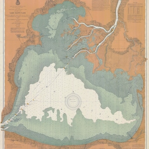 May include: A vintage nautical chart of Lake Saint Clair, showing the shoreline, waterways, and depths. The chart is printed in shades of blue, green, and brown, with a compass rose in the center.