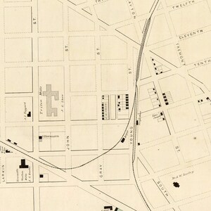 May include: A vintage map of a city with street names and building locations. The map is printed on a cream-colored paper with black ink. The map shows the streets of a city with the names "Larkin", "John", "Gray", "Young", "South", "Tremont", "Twelfth", "Eleventh", "Tenth", and "Ninth".